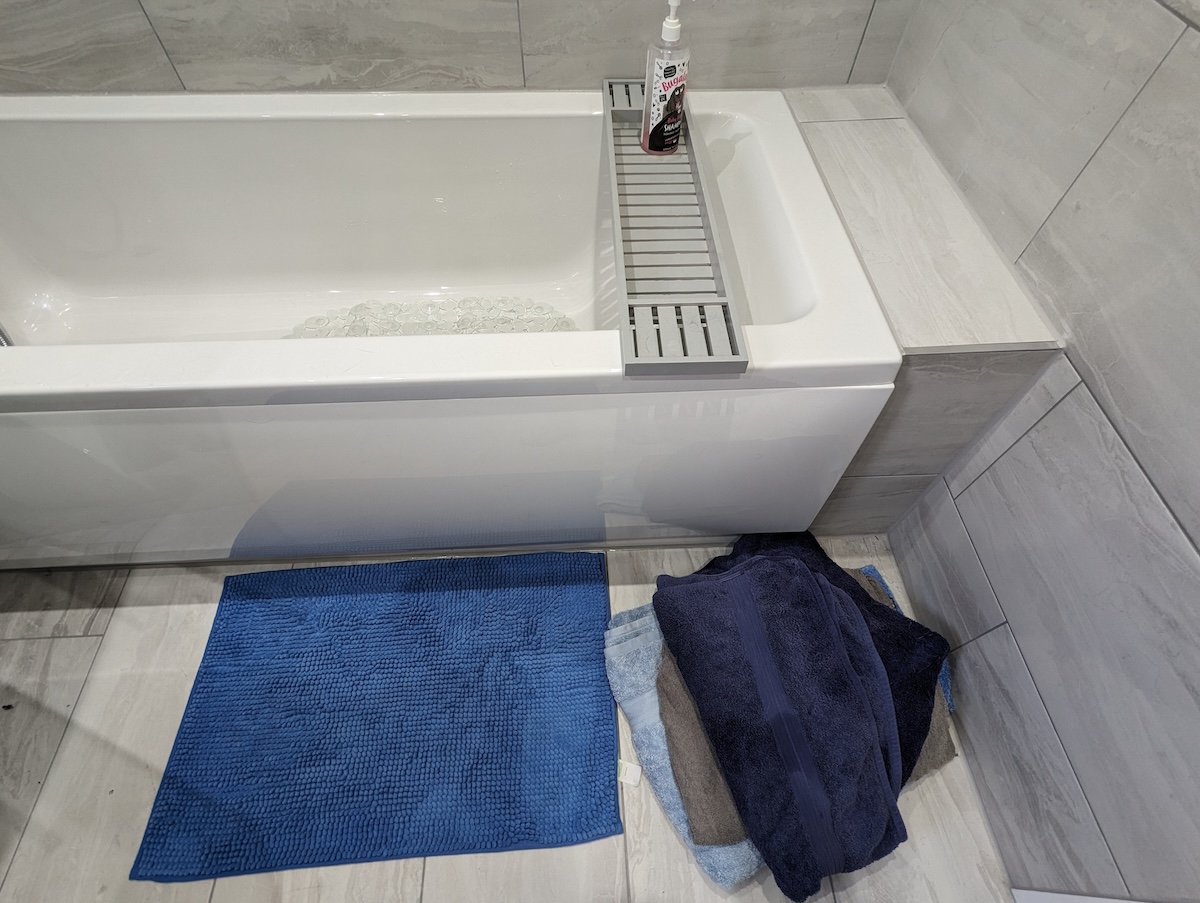 Artículos de baño para gatos: toallas, champú y alfombra antideslizante.